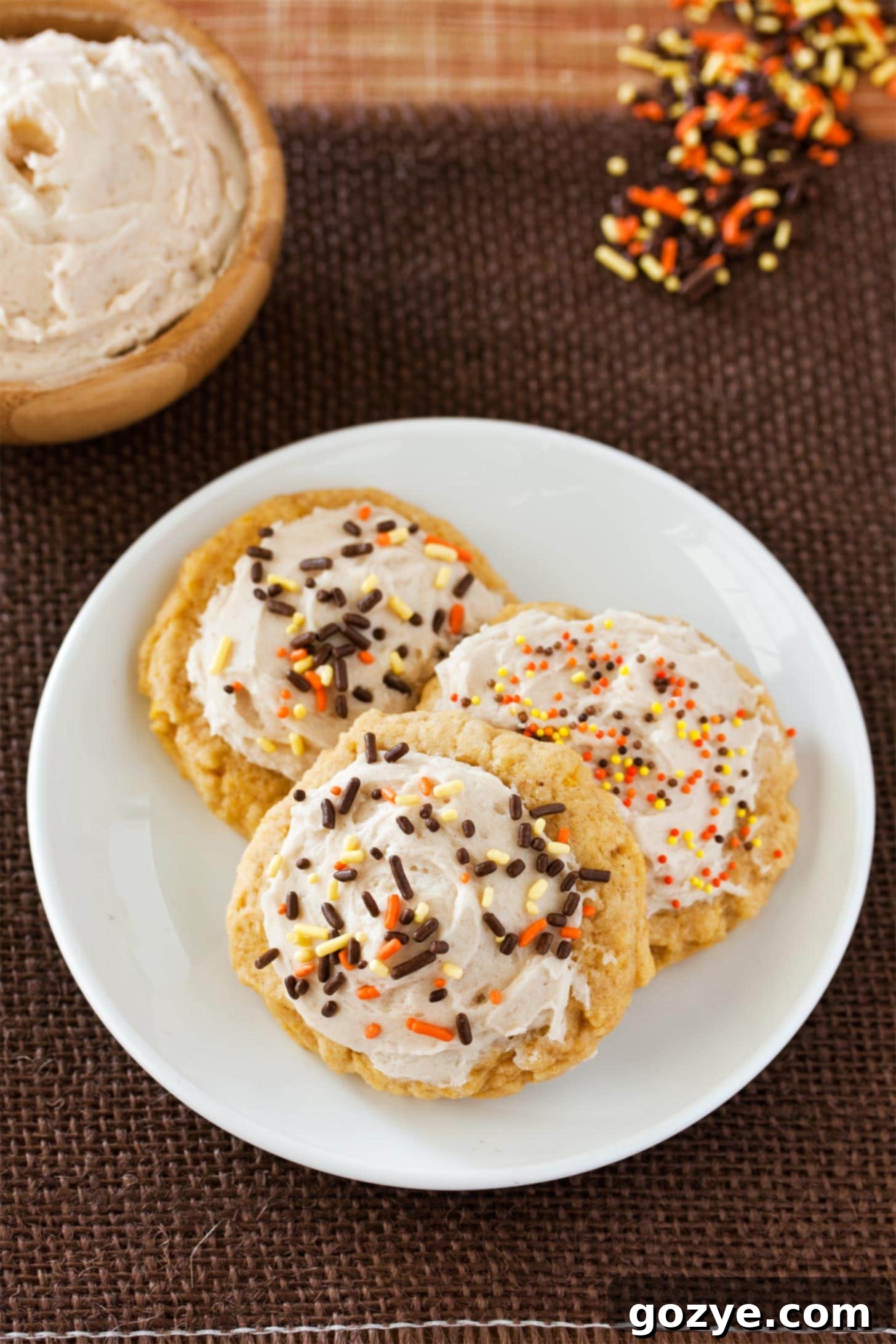 Pumpkin sugar cookies adorned with creamy cinnamon buttercream and colorful sprinkles