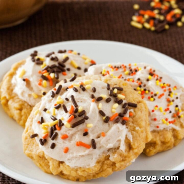 Close up of pumpkin sugar cookies with cinnamon buttercream on white plate