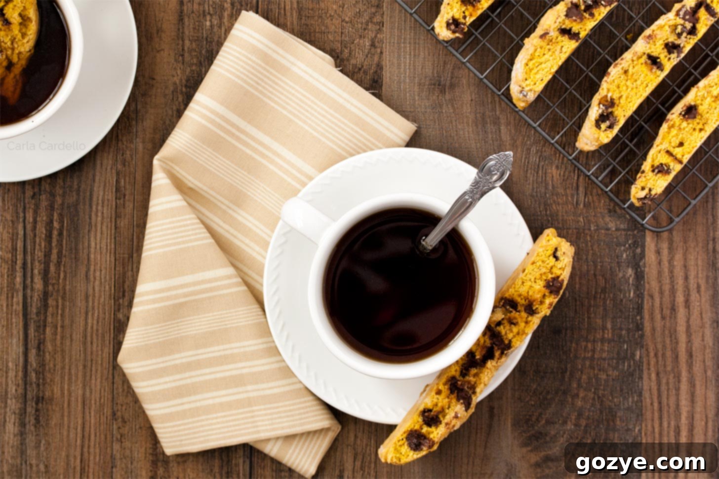 Stacked pumpkin biscotti alongside a cup of coffee, ready to be enjoyed.