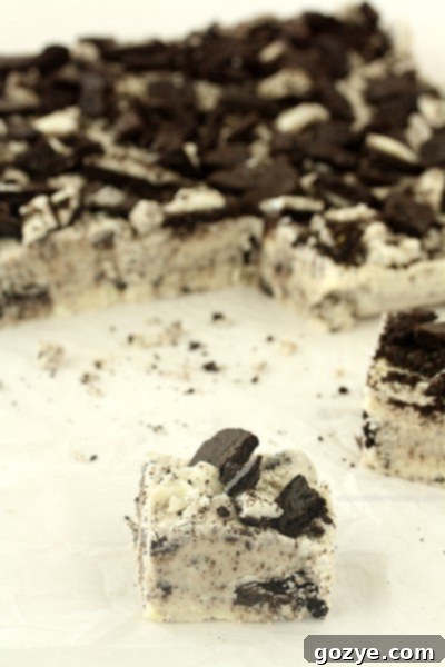 Close-up of a square of Oreo Fudge, highlighting the embedded cookie crumbs and creamy texture.