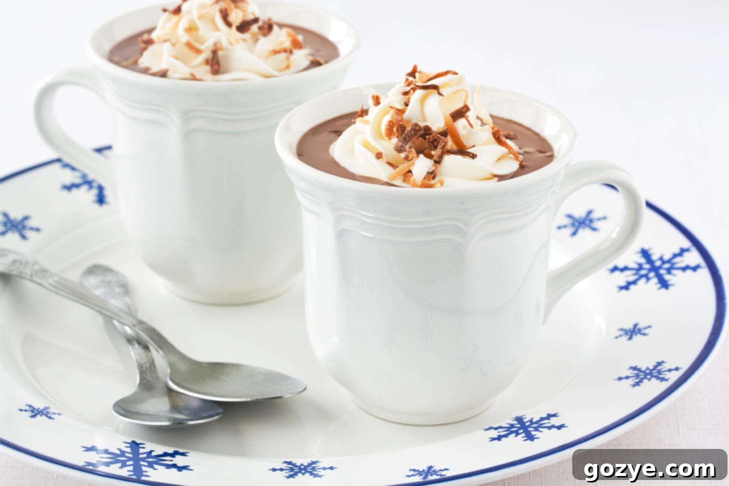 Close-up of a white mug filled with coconut milk hot chocolate, showing its thick and creamy texture, with steam rising.