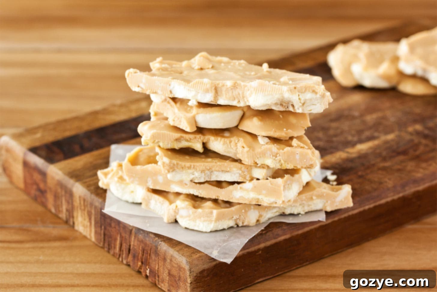 Peanut butter bark with banana stacked on cutting board