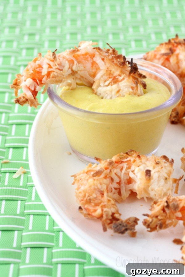 Crispy Baked Coconut Shrimp served on a white plate with a side of vibrant Mango Jalapeno Dipping Sauce