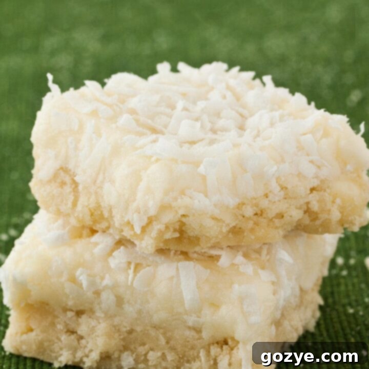 Coconut Cookie Bars stacked on top of each other with green background