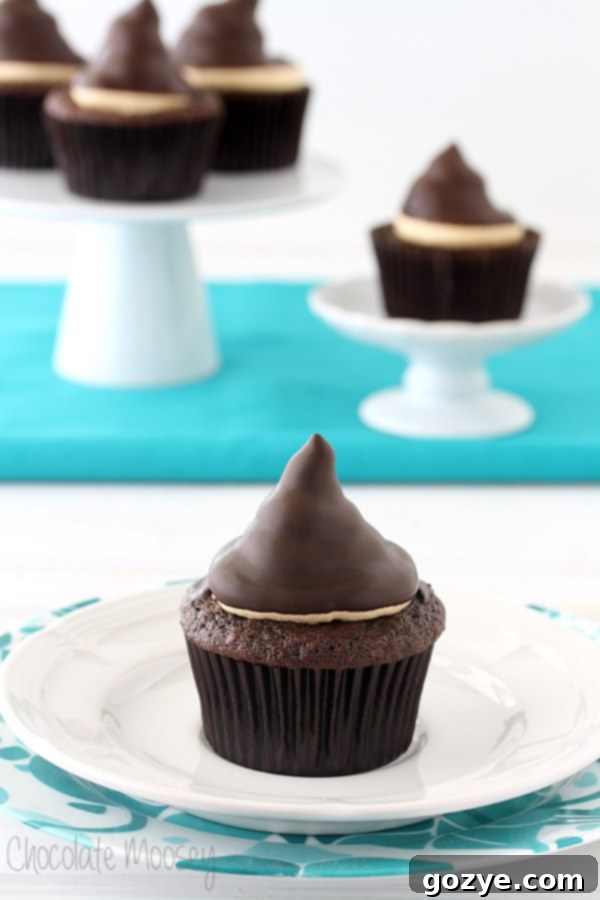 Irresistible Chocolate Caramel Hi Hat Cupcakes with a tall swirl of frosting dipped in chocolate