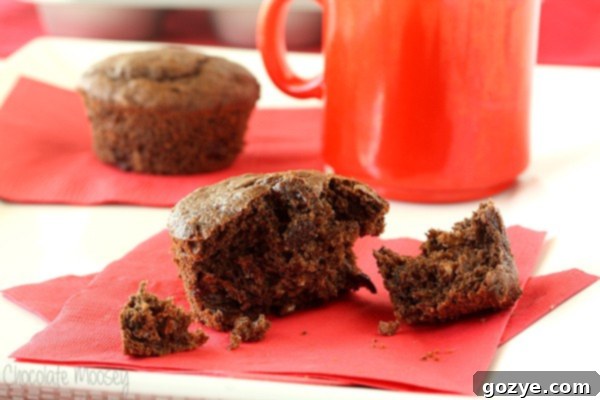 A batch of warm Chocolate-Chocolate Chip Cherry Muffins cooling on a wire rack.