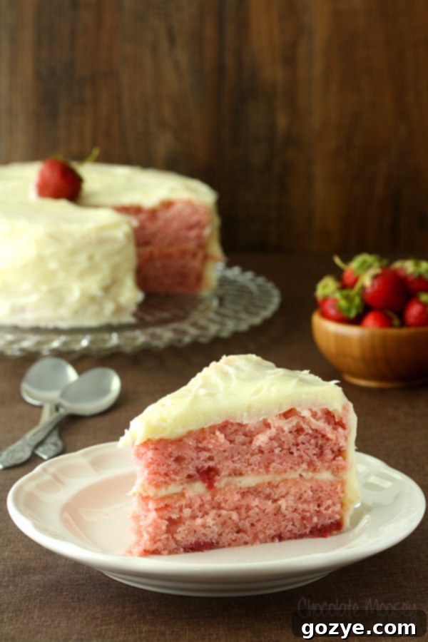 Vibrant two-layer strawberry cake with a generous layer of homemade cream cheese frosting