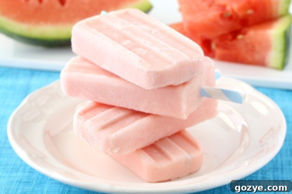 Refreshing Greek Yogurt Popsicles with watermelon pieces stacked artistically on a white plate