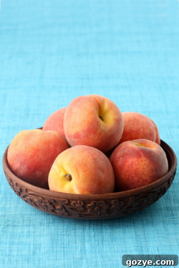 A bowl filled with peeled and diced fresh peaches, ready to be used in homemade ice cream.