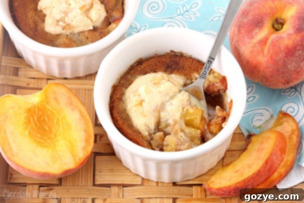 White ramekin with spoon inside peach cobbler