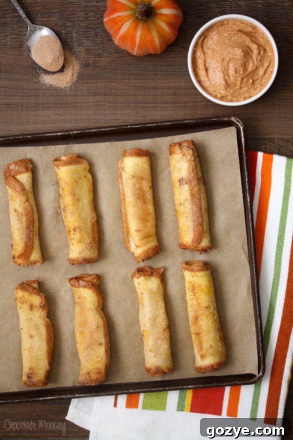 Heavenly Pumpkin Cheesecake French Toast Spirals 2 Golden brown Pumpkin Cheesecake French Toast Roll Ups arranged on a plate, ready to be dipped into a creamy Pumpkin Spice Dipping Sauce, embodying the perfect fall breakfast