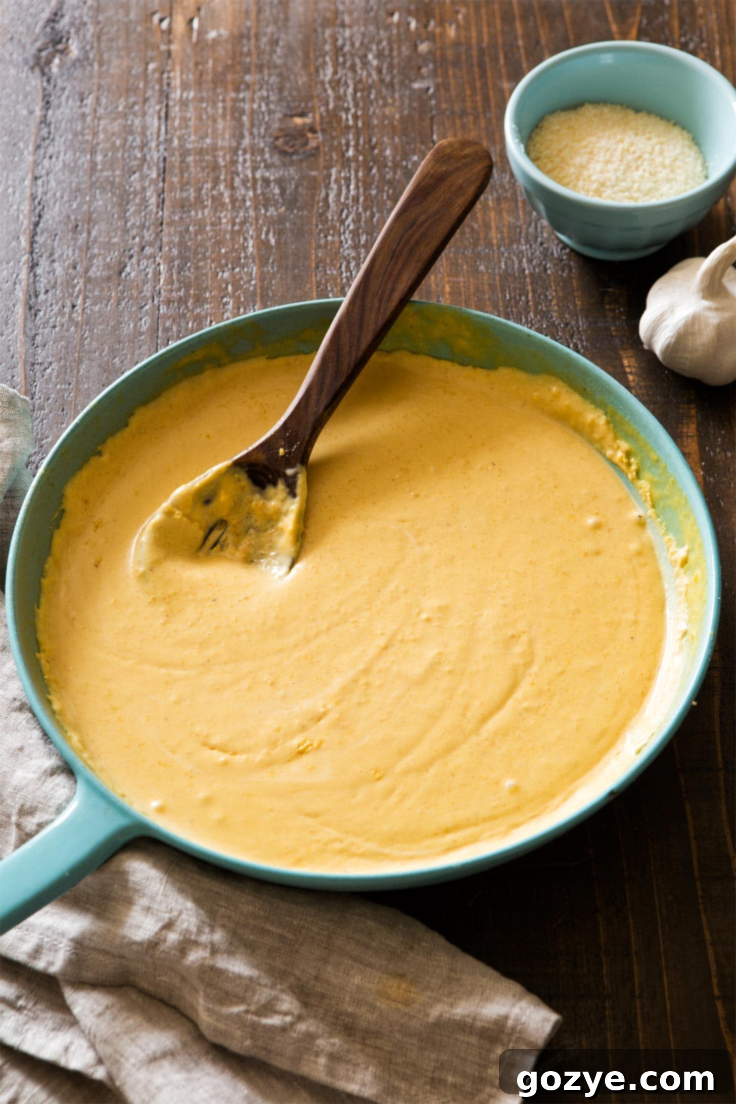 Butternut squash alfredo sauce simmering in a skillet before blending