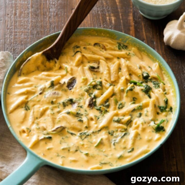 Butternut Squash Alfredo in a skillet, served with fresh herbs