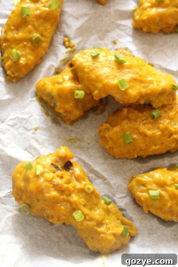 Baking tray lined with parchment paper with crispy, golden curry chicken wings arranged neatly on a roasting rack