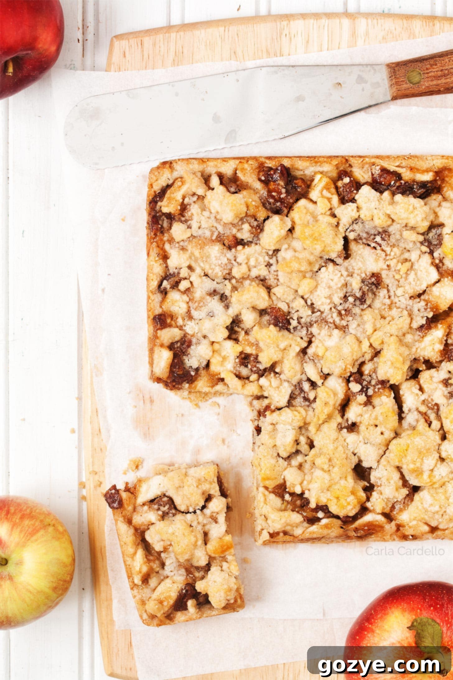 Apple Crumble Bars with a square cut, ready to be served and revealing the soft apple layer