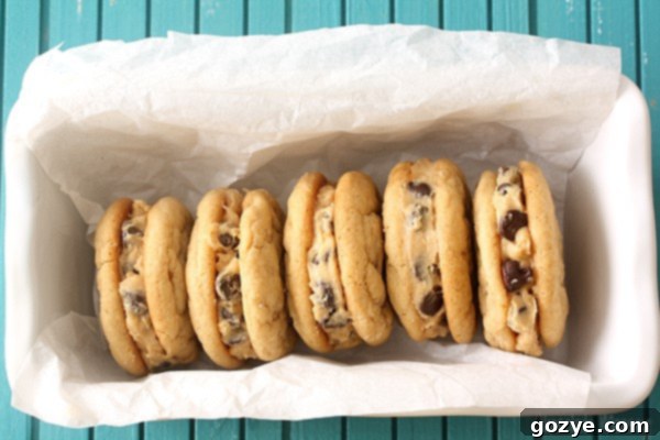 Irresistible Peanut Butter Cookie Dough Sandwiches 3 A close-up of Peanut Butter Cookie Dough Sandwich Cookies, revealing the creamy, homemade peanut butter cookie dough filling with chocolate chips.