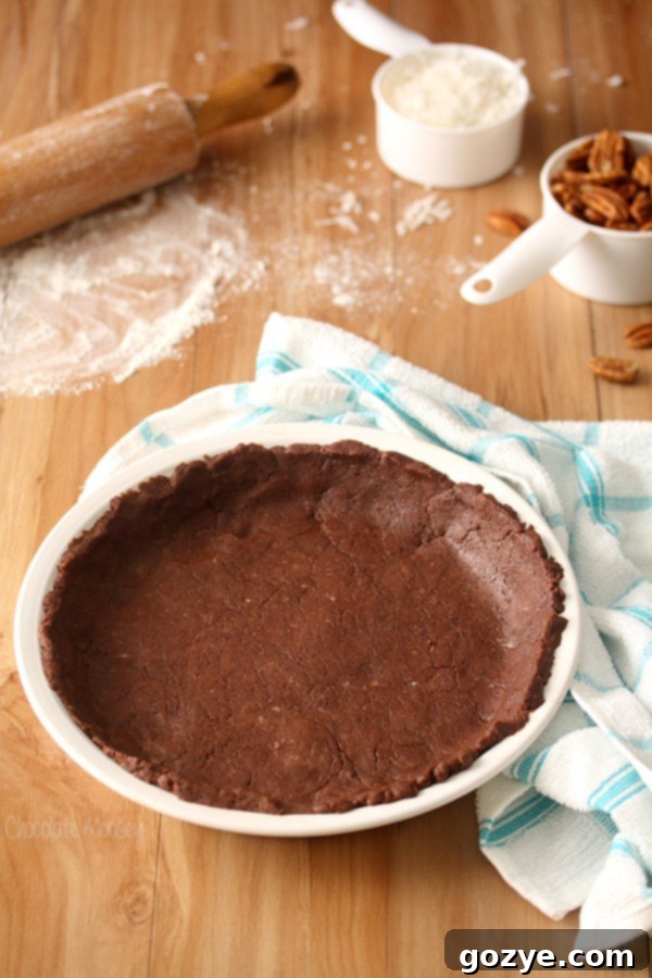 Homemade chocolate pie crust beautifully rolled out and fitted into a white pie plate, ready for filling.