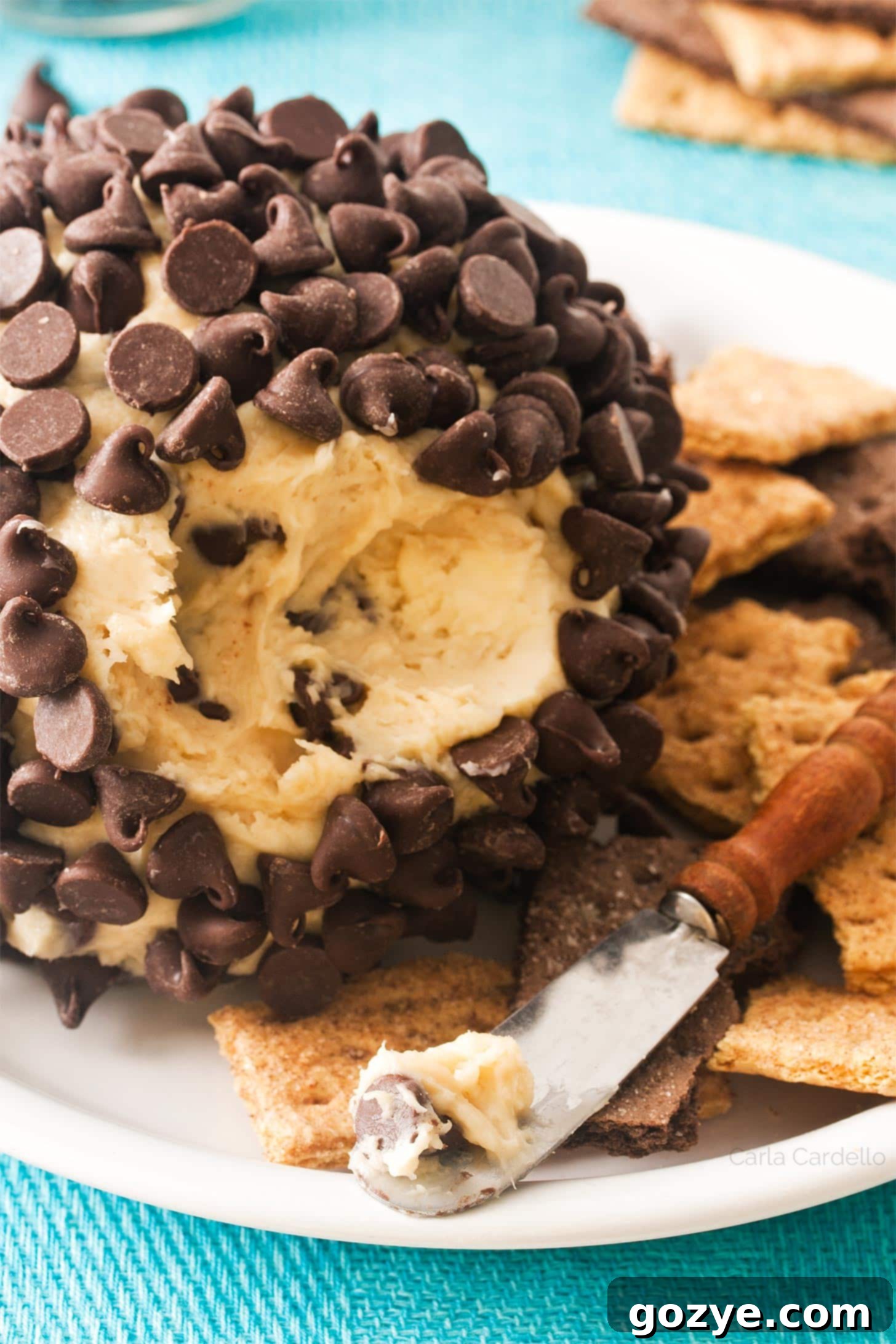 Close up of chocolate chip cheeseball on a knife, showing its creamy texture