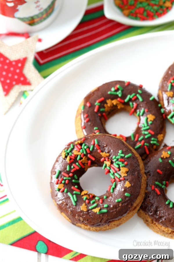 Multiple Chocolate Gingerbread Baked Doughnuts stacked on a festive plate for Christmas holiday baking