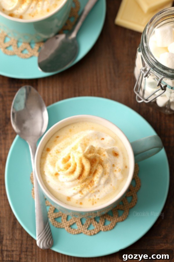 Sipable Cheesecake Cocoa 3 Close-up of Cheesecake Hot Chocolate being stirred in a saucepan, showing its creamy texture with melted white chocolate and cream cheese