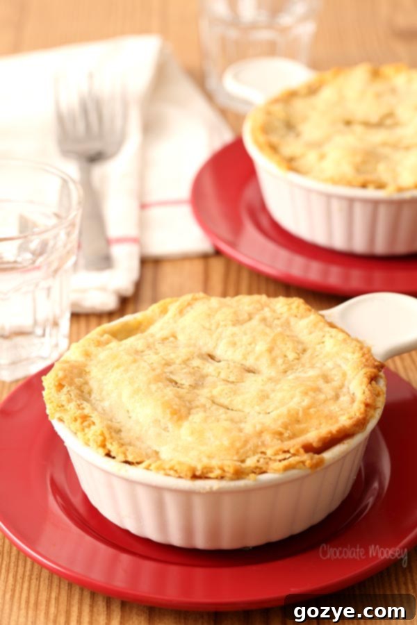 Chicken Pot Pie For Two in ramekins on red plates, golden crust