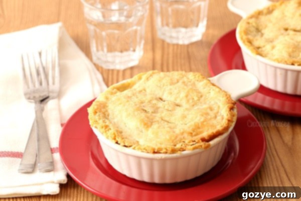 Chicken Pot Pie For Two in ramekins on red plates, golden brown crust