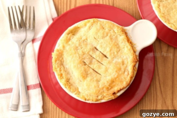Ramekin chicken pot pie on a red plate, close-up with a spoon