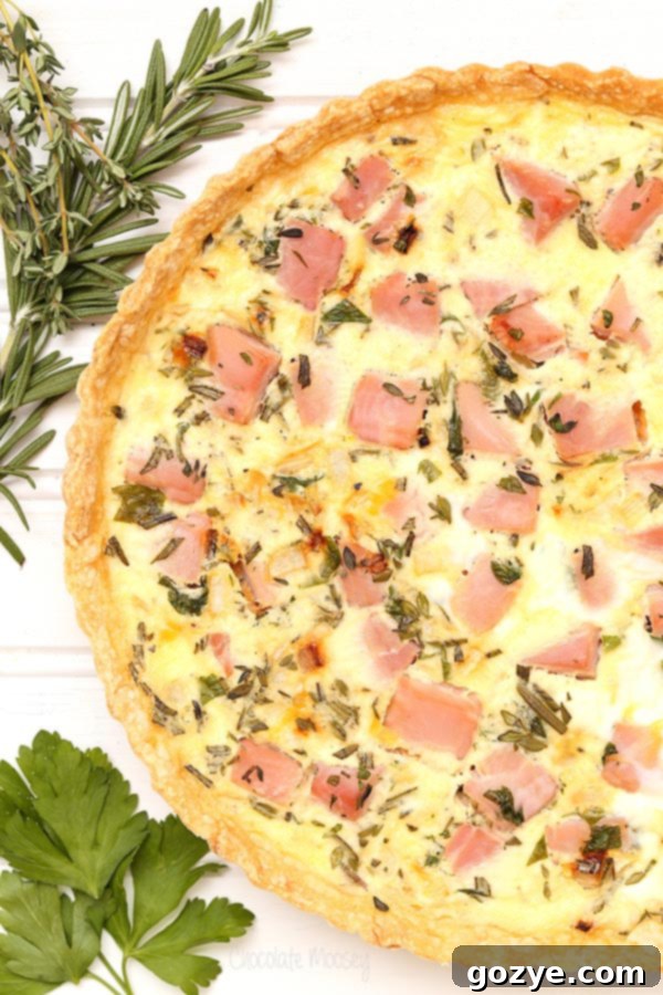 Delicious Ham and Herb Quiche with fresh rosemary, thyme, and parsley, showcasing golden crust and savory filling, perfect for Easter brunch