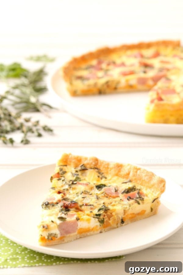 Full Ham and Herb Quiche with rosemary, thyme, and parsley on a serving platter, showcasing its beautiful presentation