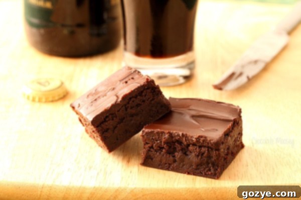 Decadent Guinness Brownies 6 A selection of fudgy beer brownies arranged on a cutting board, highlighting their rich color and the smooth texture of the chocolate glaze.