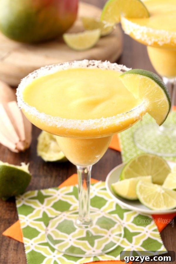 Vibrant Frozen Mango Margarita in a Glass with a Salted Coconut Rim