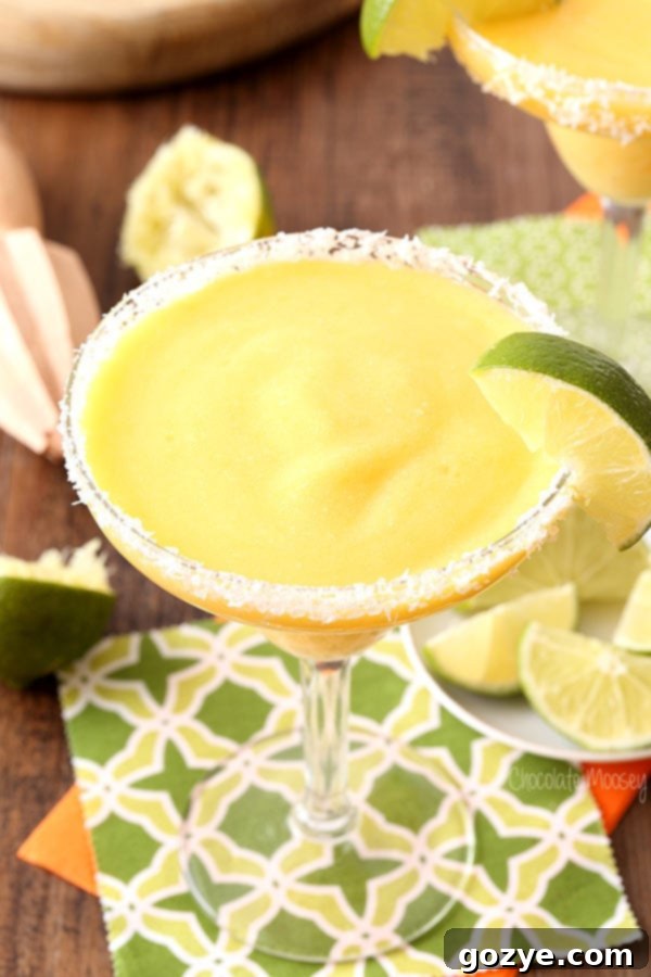 Refreshing Frozen Mango Margarita with a Lime Slice Garnish