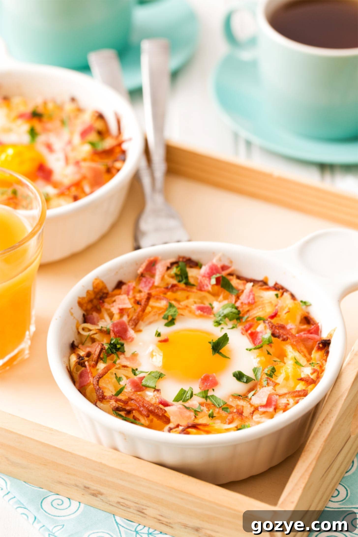 Two breakfast bowls with shredded hash browns and baked eggs, ready to be enjoyed