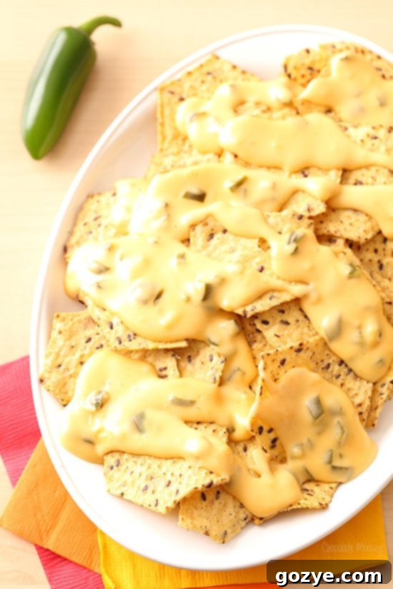 Queso poured over nachos