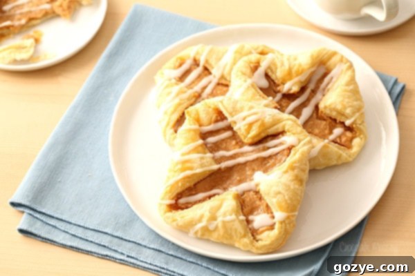 Flaky Danish Pastries 5 Puff Pastry Cream Cheese Danish on white plate with blue linen