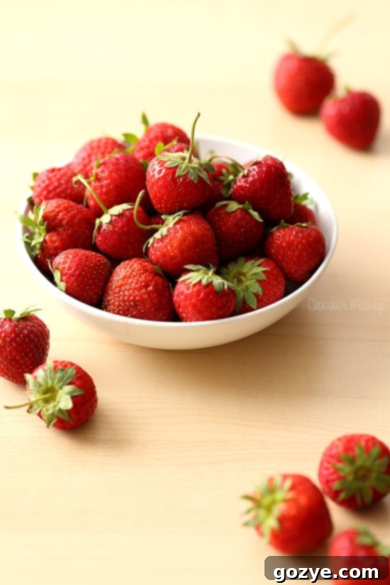 Bowl brimming with vibrant, fresh strawberries, ready for pie making.