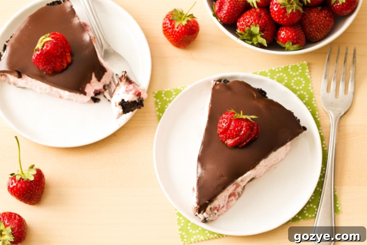 Overhead shot of two generous slices of no-bake strawberry pie, highlighting the creamy filling and ganache.