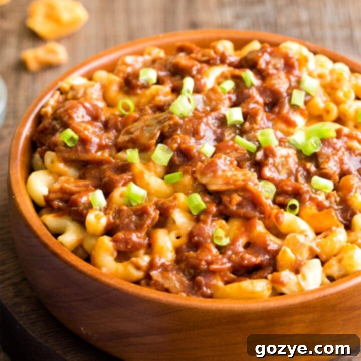 Ultimate Pulled Pork Mac and Cheese 6 Close up of pulled pork mac and cheese in brown bowl, showcasing the rich texture