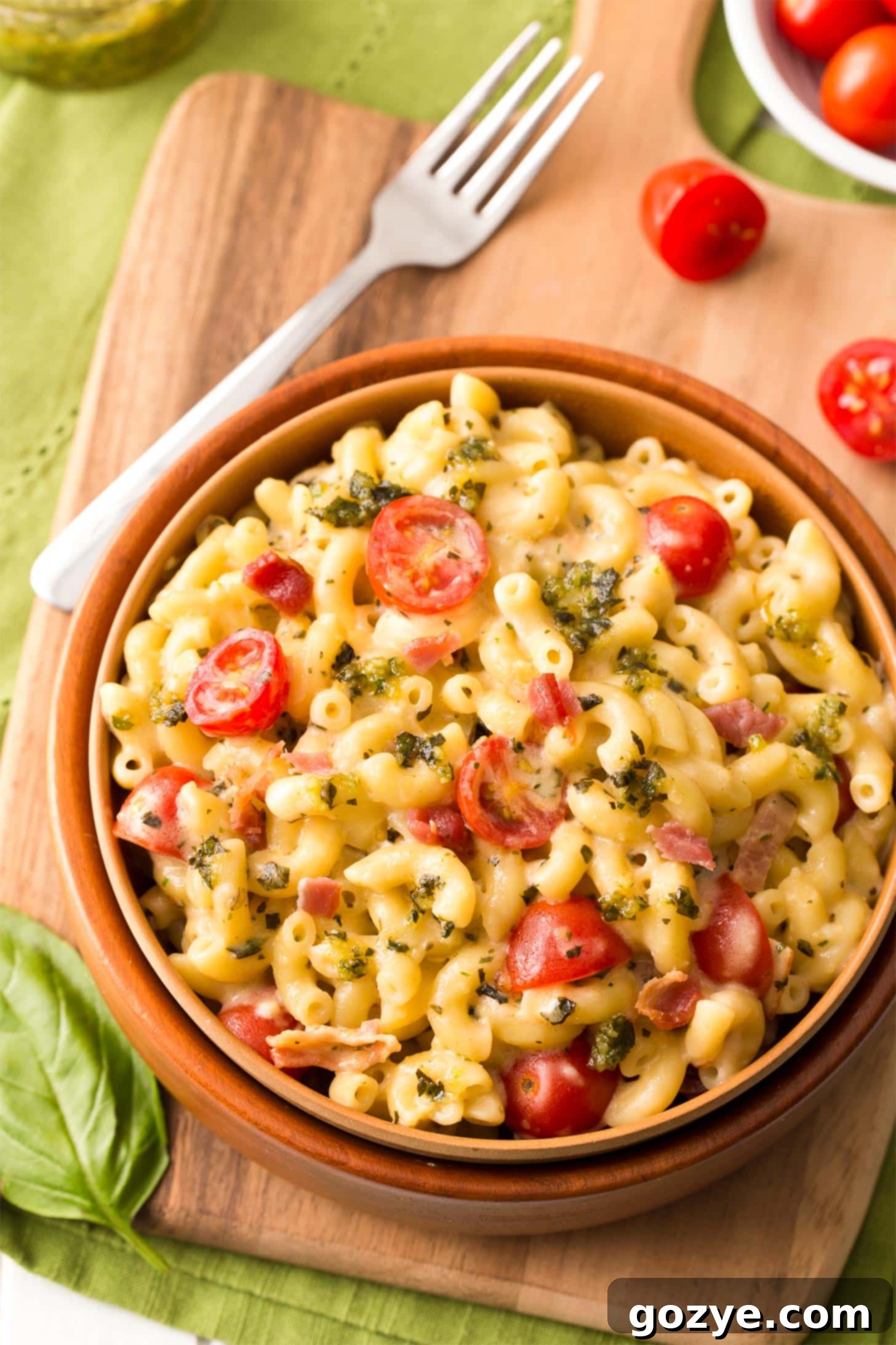 Close-up of Pesto Macaroni and Cheese with bacon, Gouda, and tomatoes in a bowl