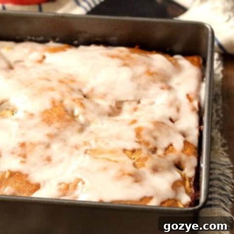 Beautifully glazed Apple Fritter Cake in an 8x8 pan, with a perfect golden crust, ready to be sliced and enjoyed.