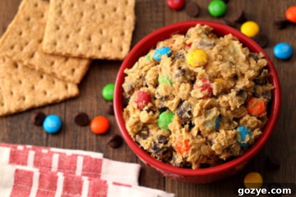 Close-up of a bowl of Monster Cookie Dough Dip, showcasing the vibrant M&Ms and rich chocolate chips, ready to be served at a gathering.
