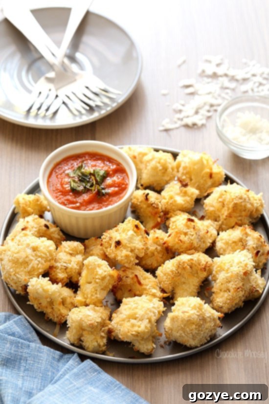 Coconut Crusted Baked Cauliflower Bites on a serving platter with dipping sauce