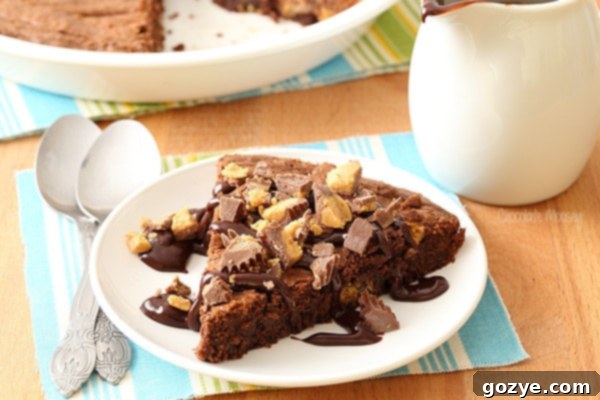 Slice of Peanut Butter Cup Brownie Pie with a chocolate drizzle
