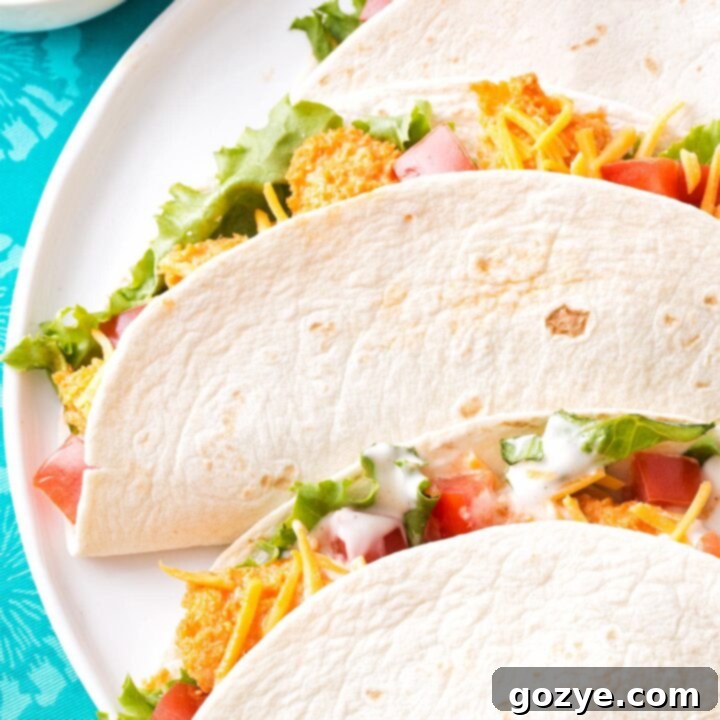 Zesty Buffalo Chicken Tacos 7 Three buffalo chicken tacos folded on a white plate, ready to be served