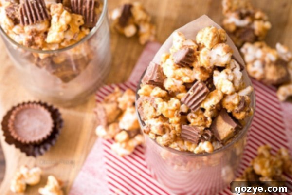 Peanut Butter Cup Popcorn scattered on a white surface, showing the delicious coating and peanut butter cups