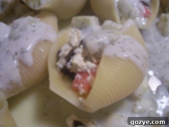 Delicious Greek Stuffed Shells baked in a dish with creamy sauce.