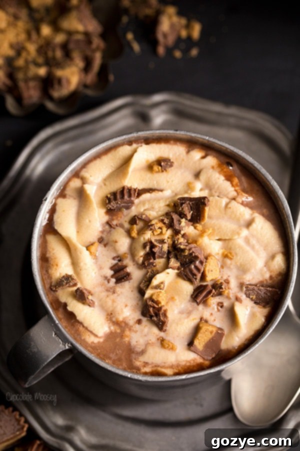 Peanut Butter Hot Cocoa being carefully poured into a pewter mug, highlighting its rich texture.