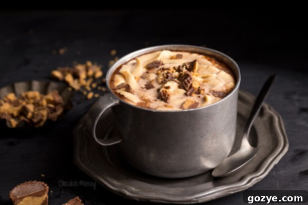 Close-up shot of Peanut Butter Hot Chocolate in a rustic pewter mug, showcasing its creamy texture.