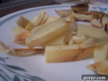 Crispy homemade baked French fries on a baking sheet, seasoned and ready to eat.