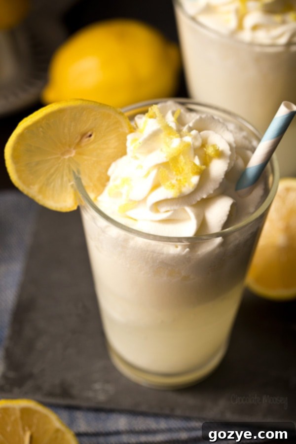 Two glasses of Lemon Drop Cream Soda, one with whipped cream and a lemon wedge, the other plain.